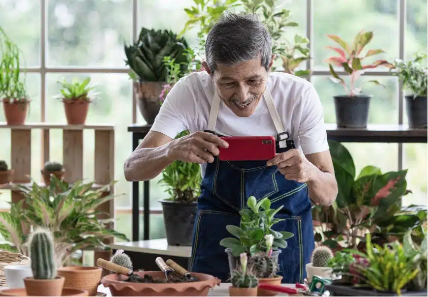 A person using a mobile device to photograph plants