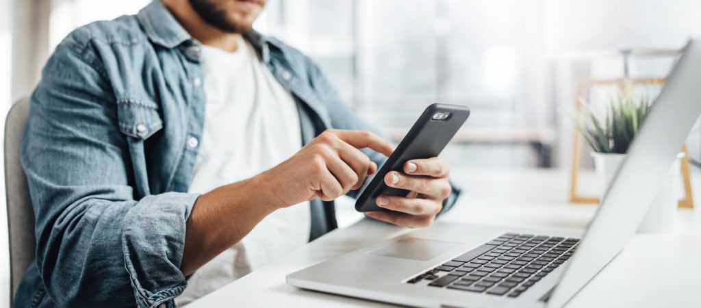 A person holding a mobile device and posting to social media