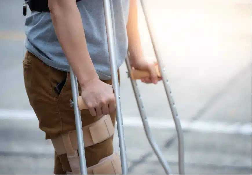 A person walking with a leg injury and crutches