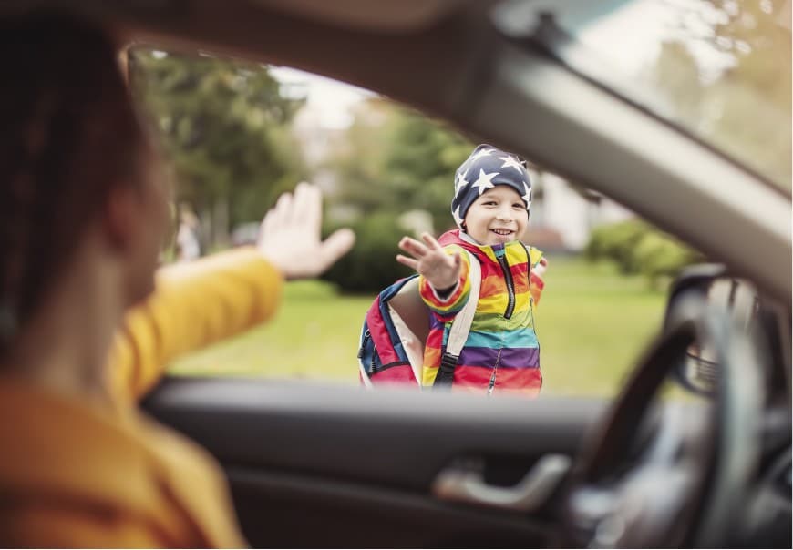 A child waving good-bye to a parent