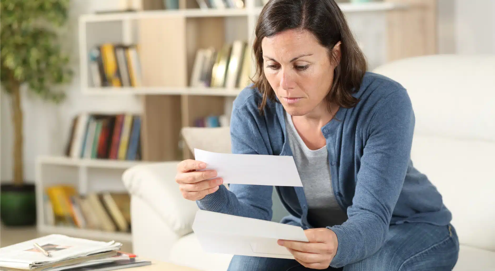 A woman looking at a check received in the mail