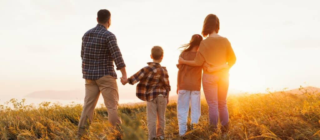 A father walking with his children through a field