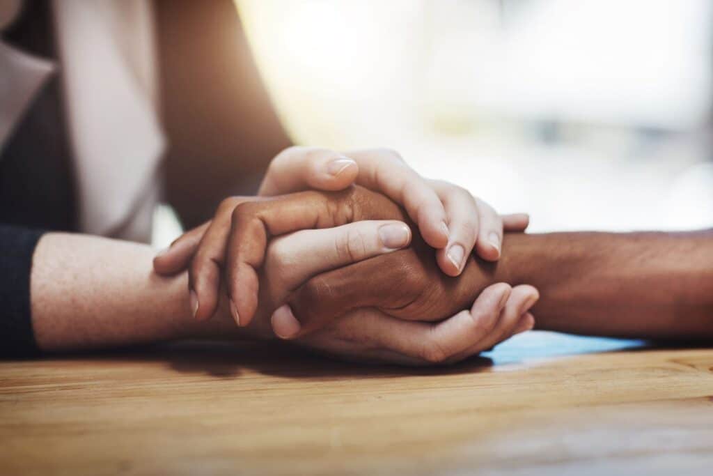 Two people clasping hands in comfort after losing a loved one in a North Carolina wrongful death case