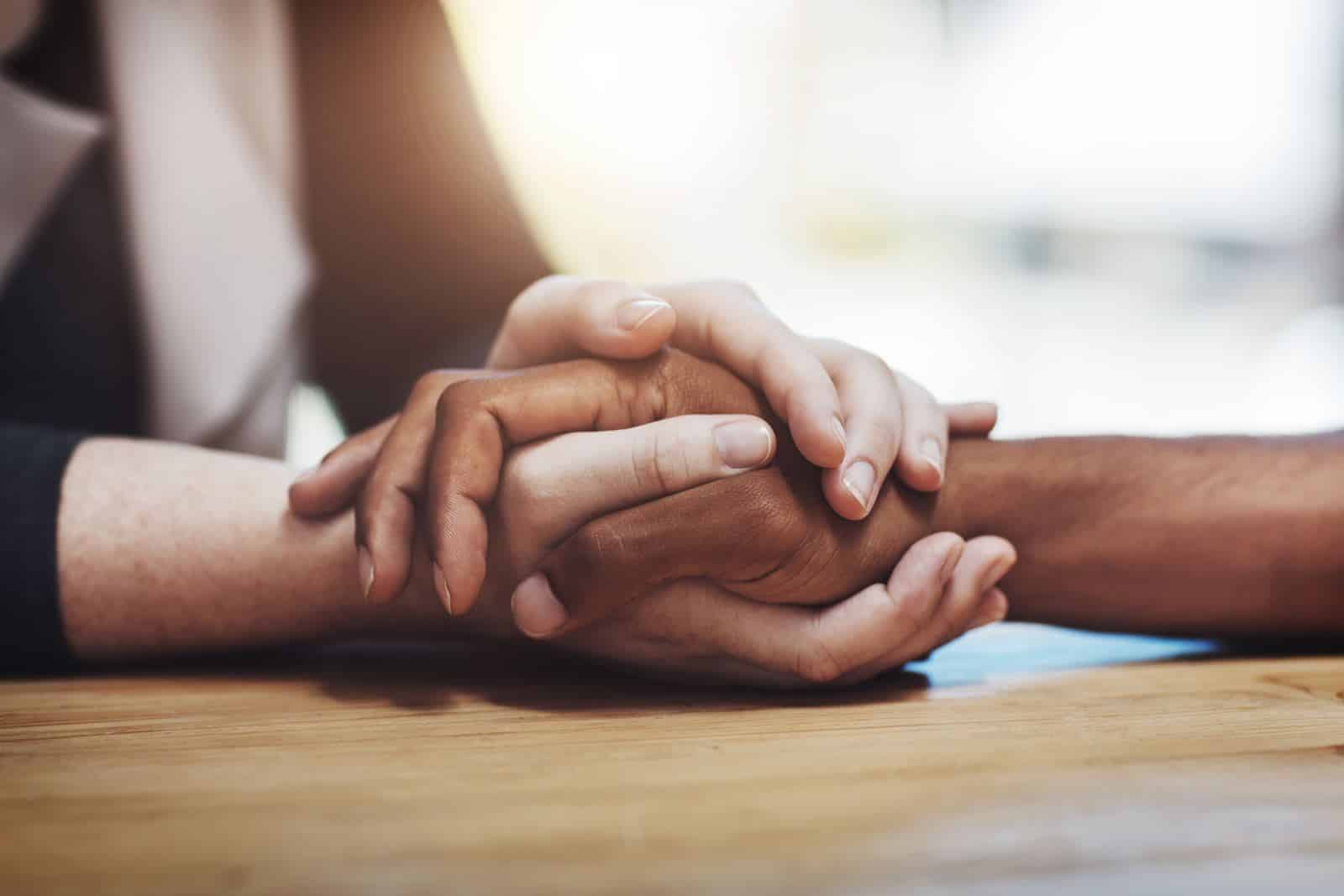 How to File a Wrongful Death Case in North Carolina 1 Two people clasping hands in comfort after losing a loved one in a North Carolina wrongful death case
